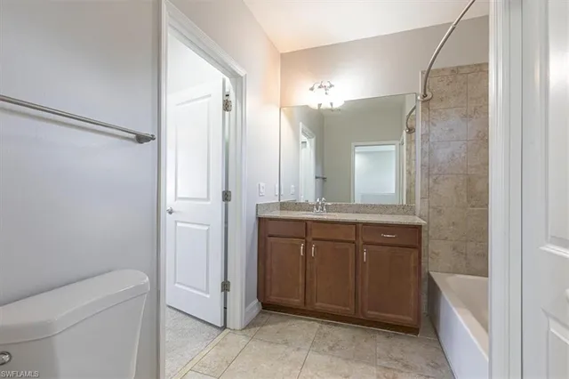 a bathroom with a granite countertop sink mirror and toilet