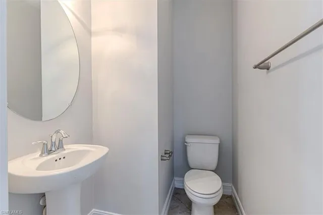 a bathroom with a toilet a sink and a mirror
