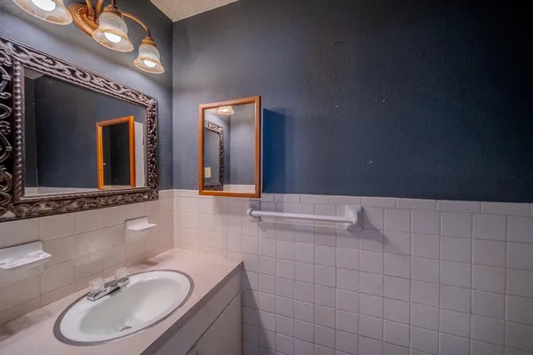 a bathroom with a granite countertop sink a mirror and a bathtub