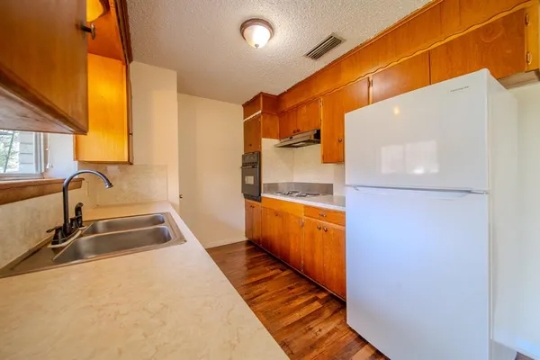 a kitchen with granite countertop a sink and a stove top oven
