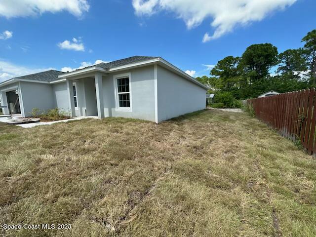 a view of backyard of house with wooden fence