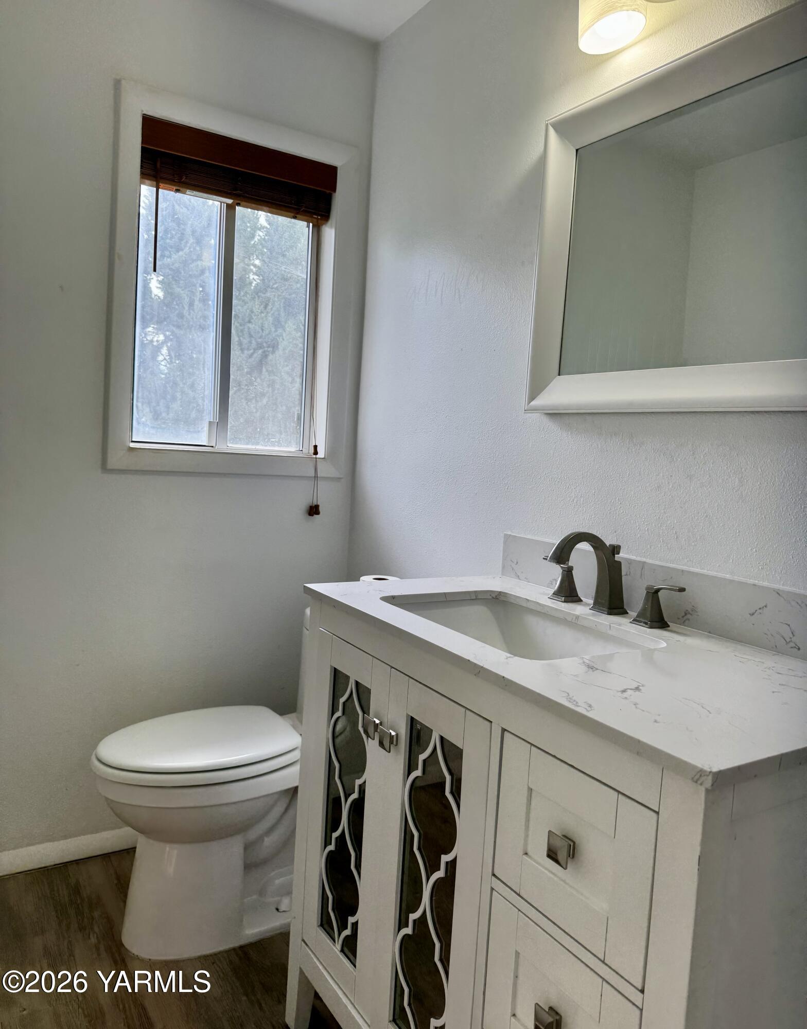 7801 Campbell Road, Unit 1 Toppenish, WA 98948 - Photo 13 of 46 a bathroom with a granite countertop toilet sink and mirror