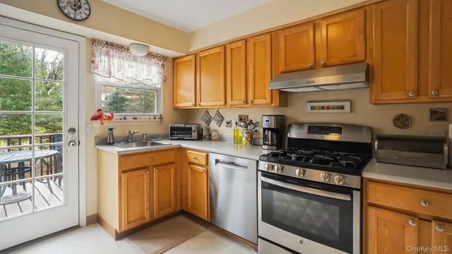 a kitchen with granite countertop a stove a sink and cabinetry