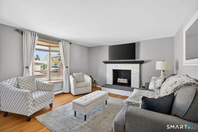 a living room with furniture a flat screen tv and a fireplace