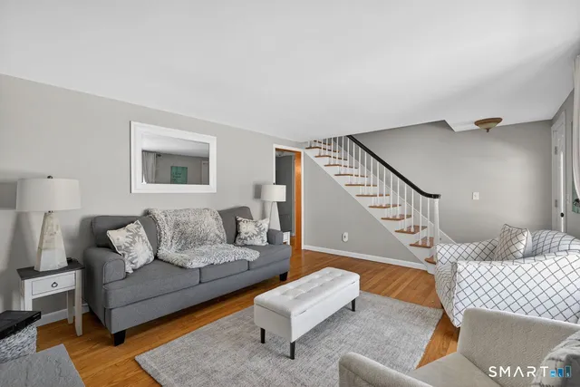 a living room with furniture and wooden floor