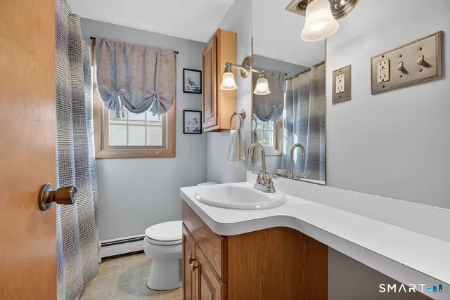 a bathroom with a toilet a sink and mirror