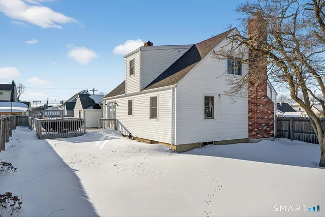 a view of a white house with a snow in the background