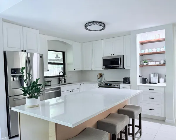 a kitchen with stainless steel appliances a microwave sink refrigerator and cabinets