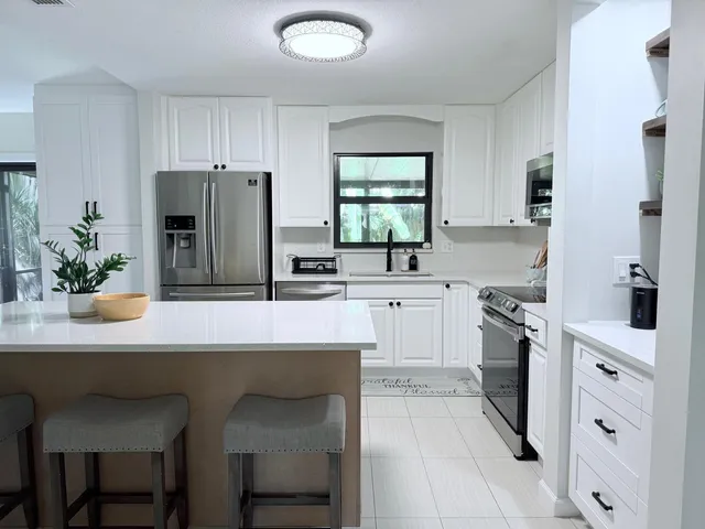a kitchen with white cabinets and stainless steel appliances