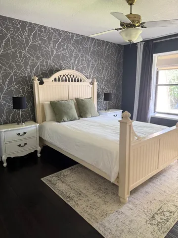 a bedroom with a bed and a ceiling fan