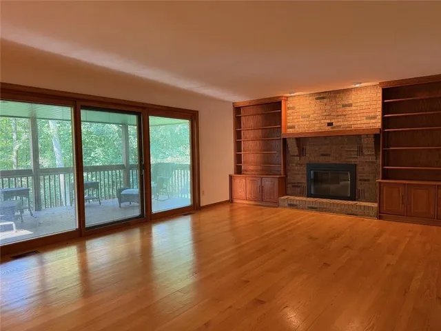 a view of a big room with wooden floor and windows