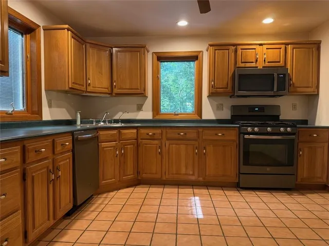 a kitchen with stainless steel appliances granite countertop a refrigerator and a sink