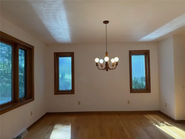 a view of a livingroom with a chandelier wooden floor and a chandelier