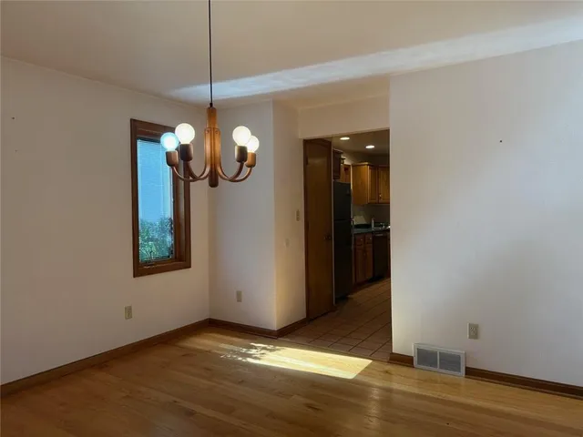 a view of a room with wooden floor and chandelier