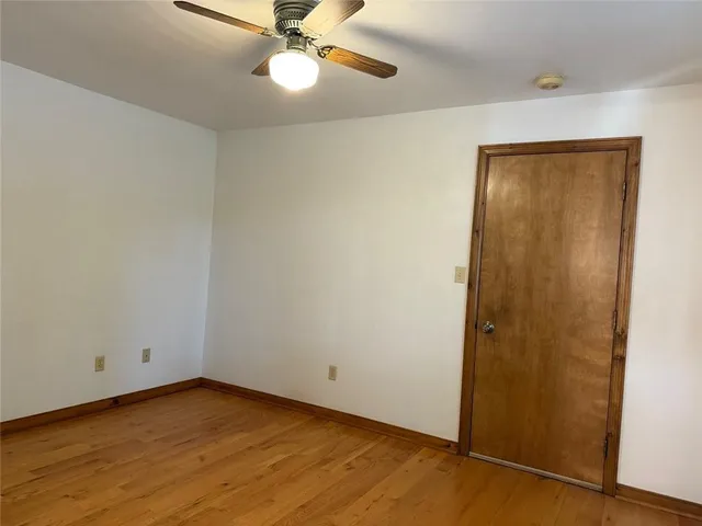 an empty room with window and closet area