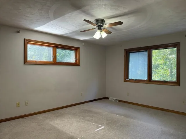 an empty room with closet and a chandelier fan