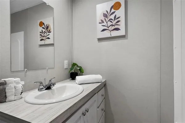 a bathroom with a sink a mirror and vanity