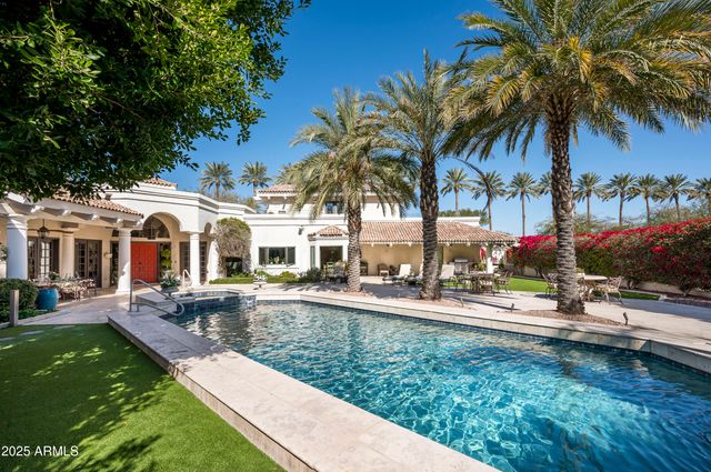 a view of a house with a swimming pool and sitting area