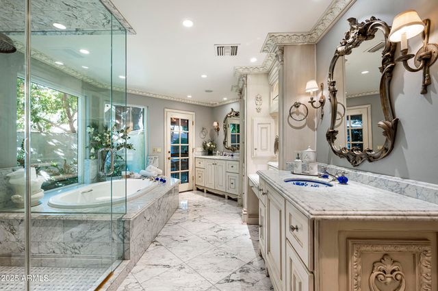 a spacious bathroom with a tub sink and mirror