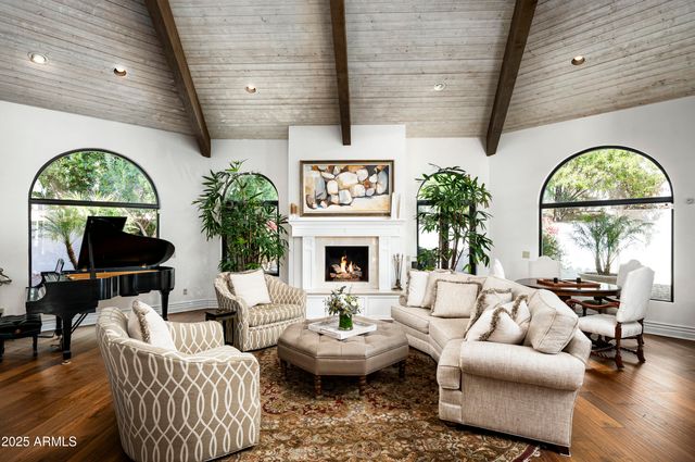 a living room with furniture a fireplace and a large window