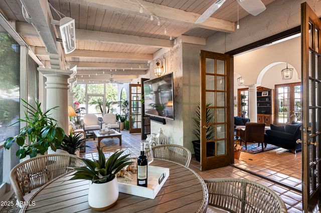 a living room with patio furniture dining table and a potted plant