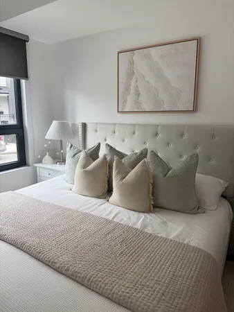 a large bed sitting in a bedroom and painting on the wall
