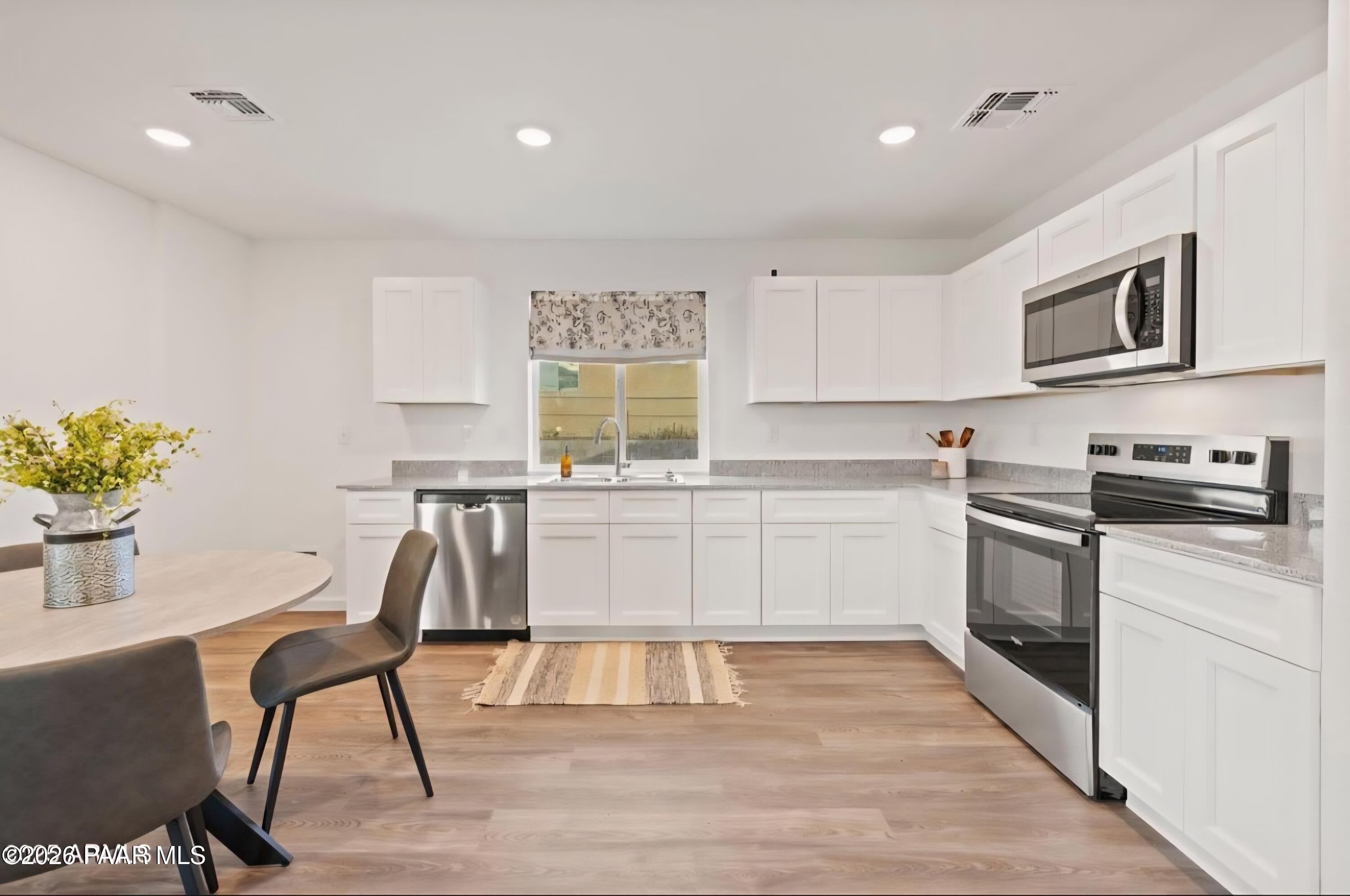 20182 East Lakeside Road Cordes Lakes, AZ 86333 - Photo 3 of 20 a kitchen with granite countertop white cabinets and white appliances