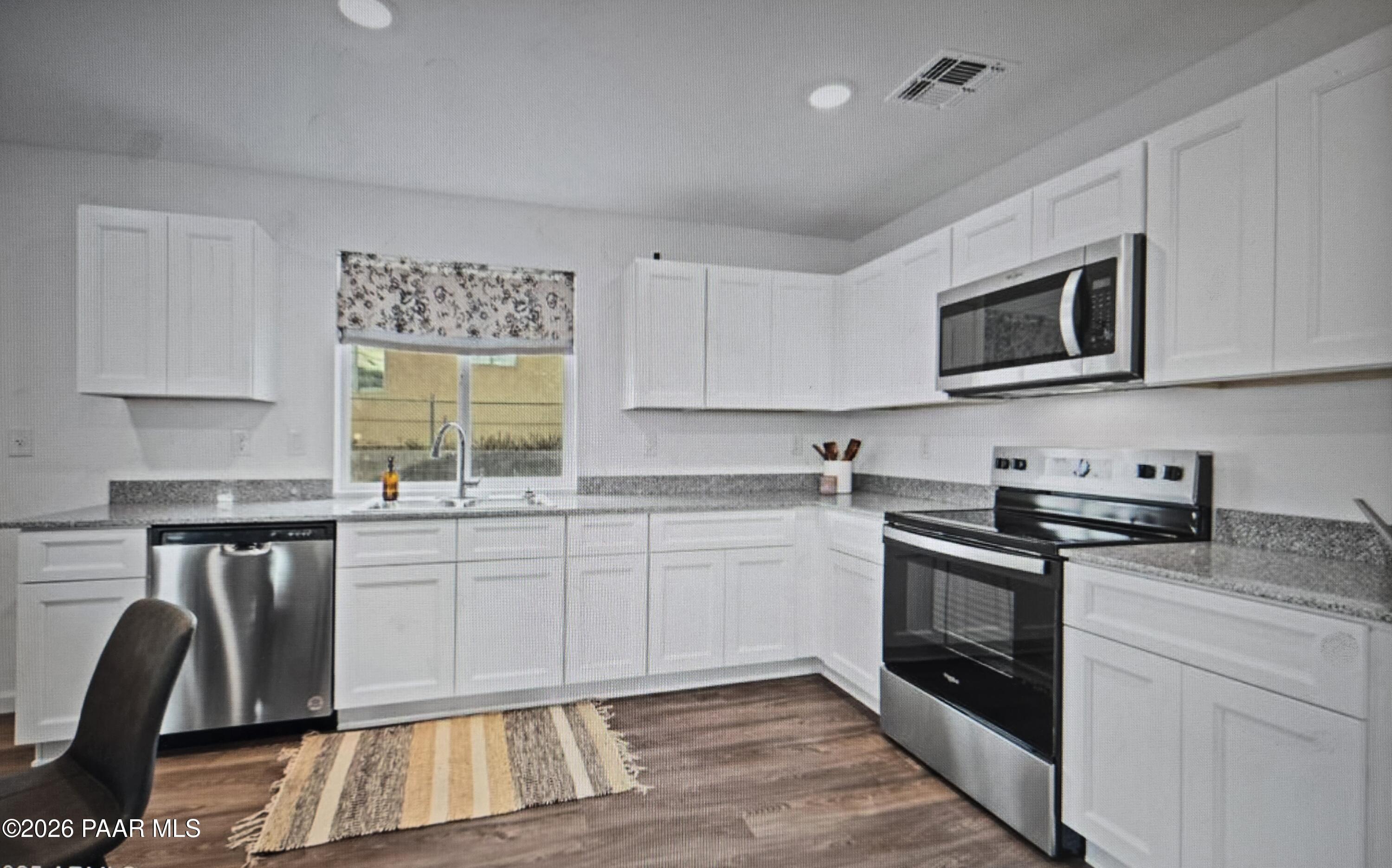 20182 East Lakeside Road Cordes Lakes, AZ 86333 - Photo 4 of 20 a kitchen with stainless steel appliances granite countertop a stove a sink and a microwave