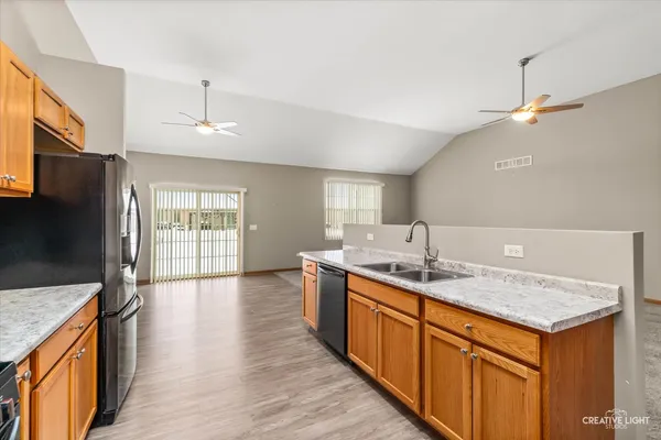 a kitchen with stainless steel appliances granite countertop a sink a stove and a wooden floors