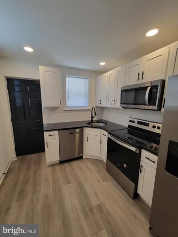 a large kitchen with stainless steel appliances granite countertop a stove a sink and a refrigerator