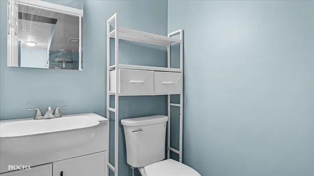 a bathroom with a toilet sink and mirror