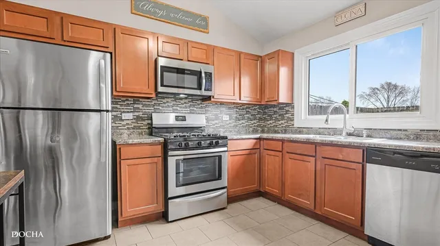 a kitchen with stainless steel appliances granite countertop a refrigerator stove top oven and sink