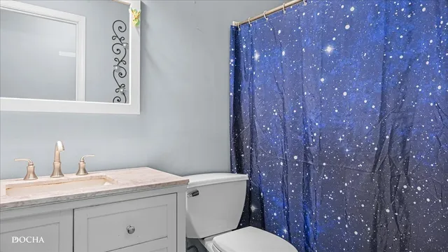 a bathroom with a granite countertop sink mirror vanity and toilet