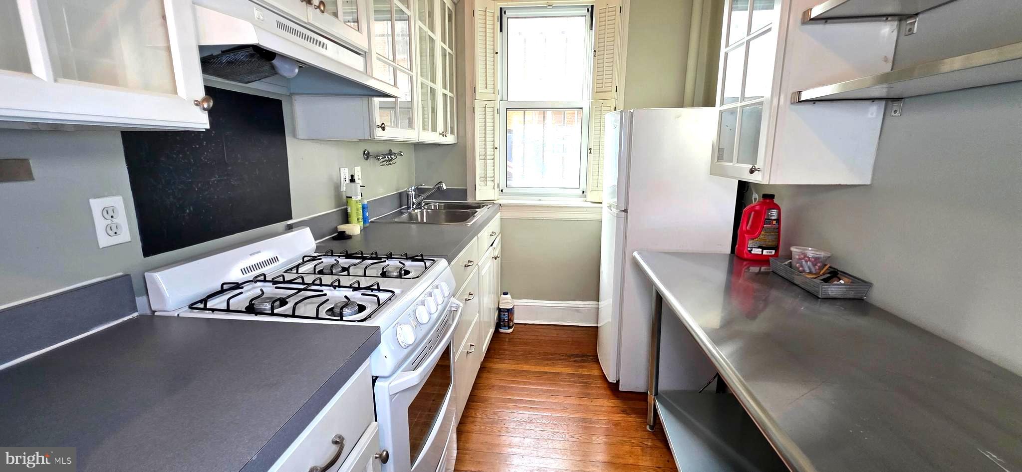 1954 Columbia Road Northwest, Unit 104 Washington, DC 20009 - Photo 13 of 18 a kitchen with a stove and a refrigerator