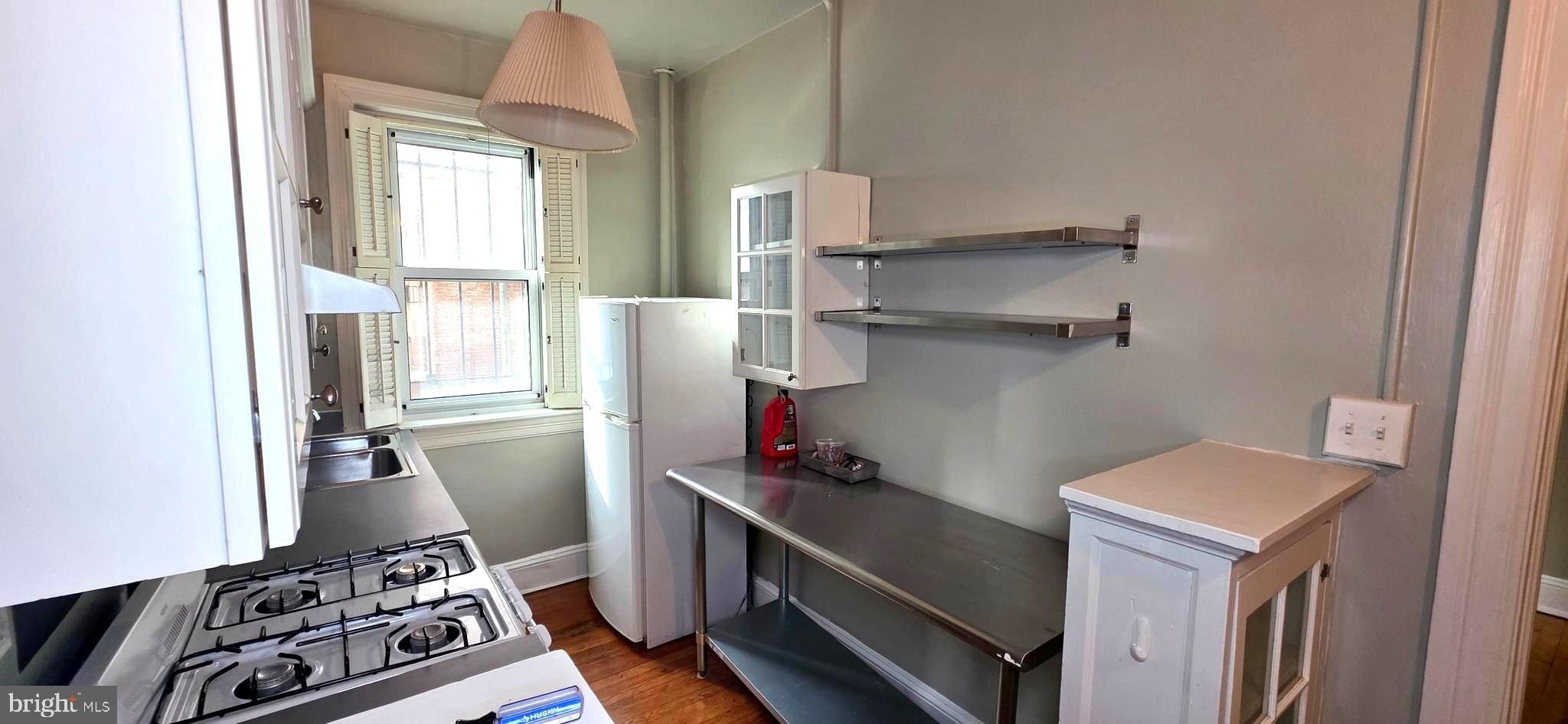 1954 Columbia Road Northwest, Unit 104 Washington, DC 20009 - Photo 16 of 18 a kitchen with a refrigerator and a stove