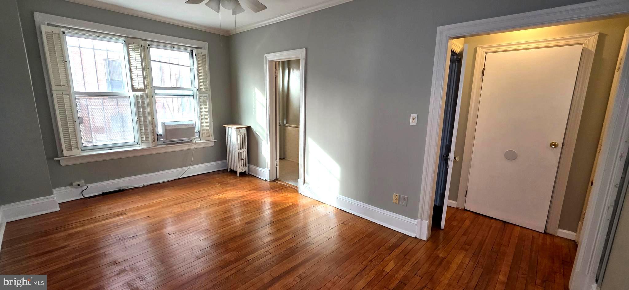 1954 Columbia Road Northwest, Unit 104 Washington, DC 20009 - Photo 8 of 18 an empty room with wooden floor and windows