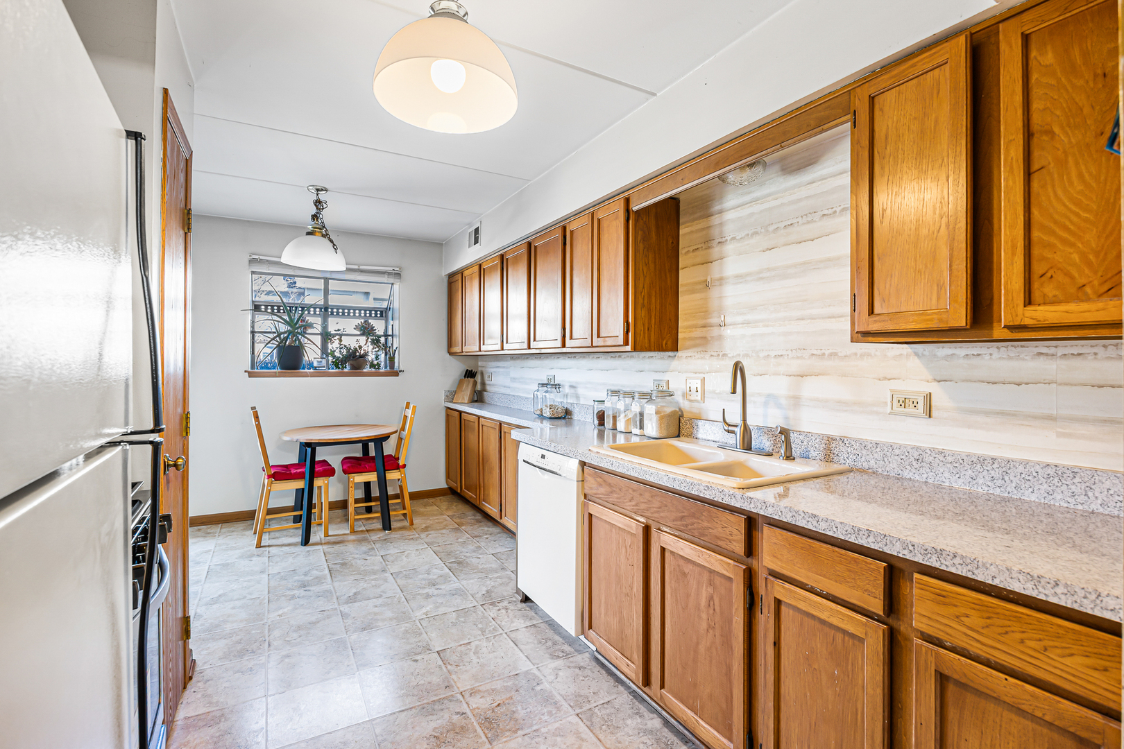 1226 Chalet Road, Unit 2102 Naperville, IL 60563 - Photo 7 of 28 a very nice looking kitchen with granite countertop a sink cabinets and appliances