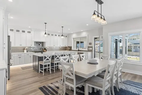 a view of a dining room and livingroom with furniture wooden floor a chandelier