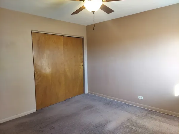 an empty room with a ceiling fan and a window