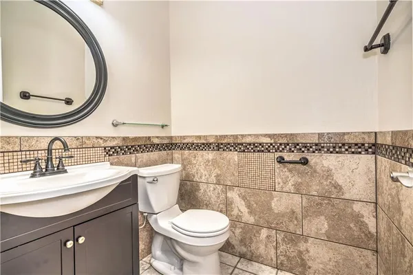 a bathroom with a granite countertop toilet sink and mirror
