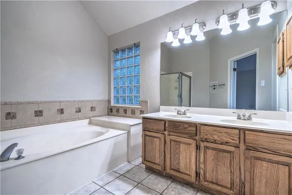 a bathroom with a tub a sink and mirror