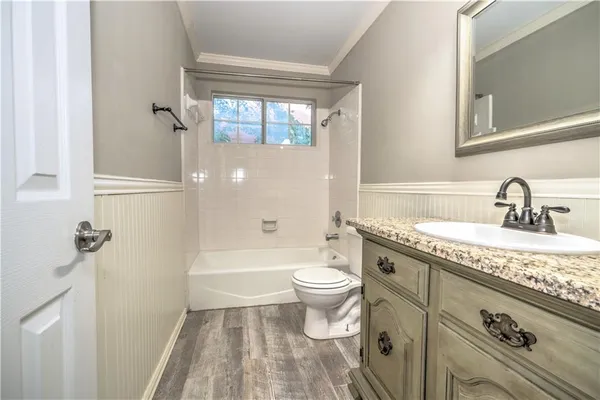 a bathroom with a granite countertop toilet a sink and a bathtub