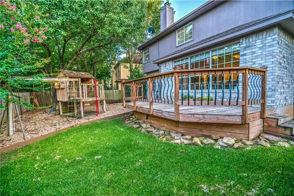 a view of a chair and table in backyard of the house