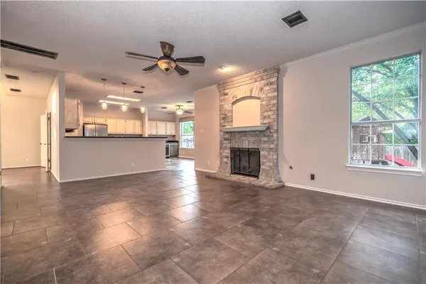 an empty room with windows and fireplace