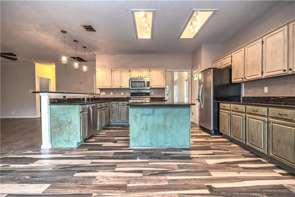 a kitchen with stainless steel appliances granite countertop a refrigerator and a stove top oven
