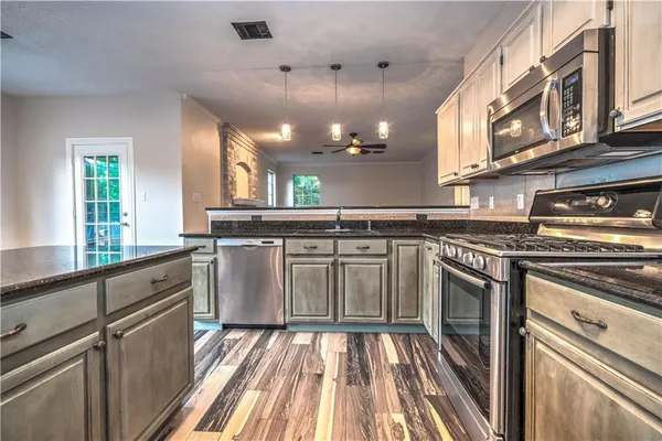 a kitchen with stainless steel appliances granite countertop a stove a sink and a refrigerator