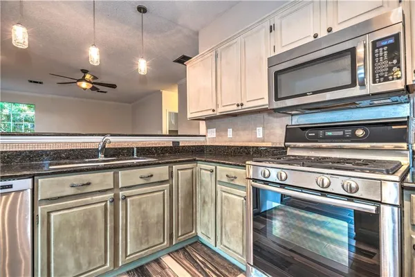 a kitchen with stainless steel appliances granite countertop a stove and a microwave