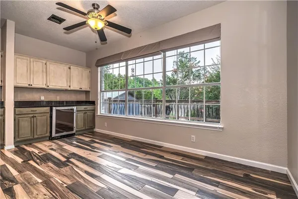 a view of a kitchen with wooden floor and a window