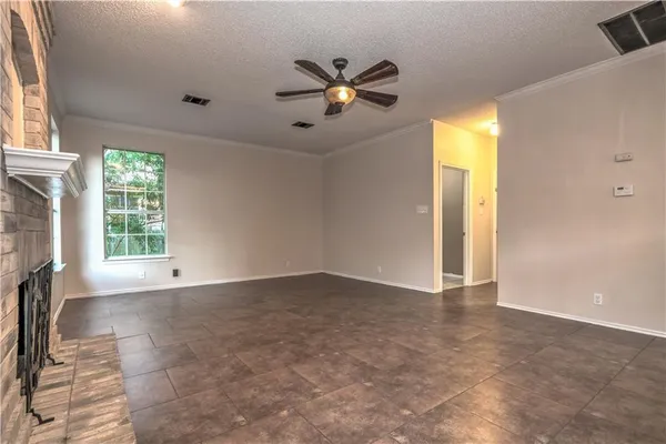 a view of an empty room with a fireplace and a window