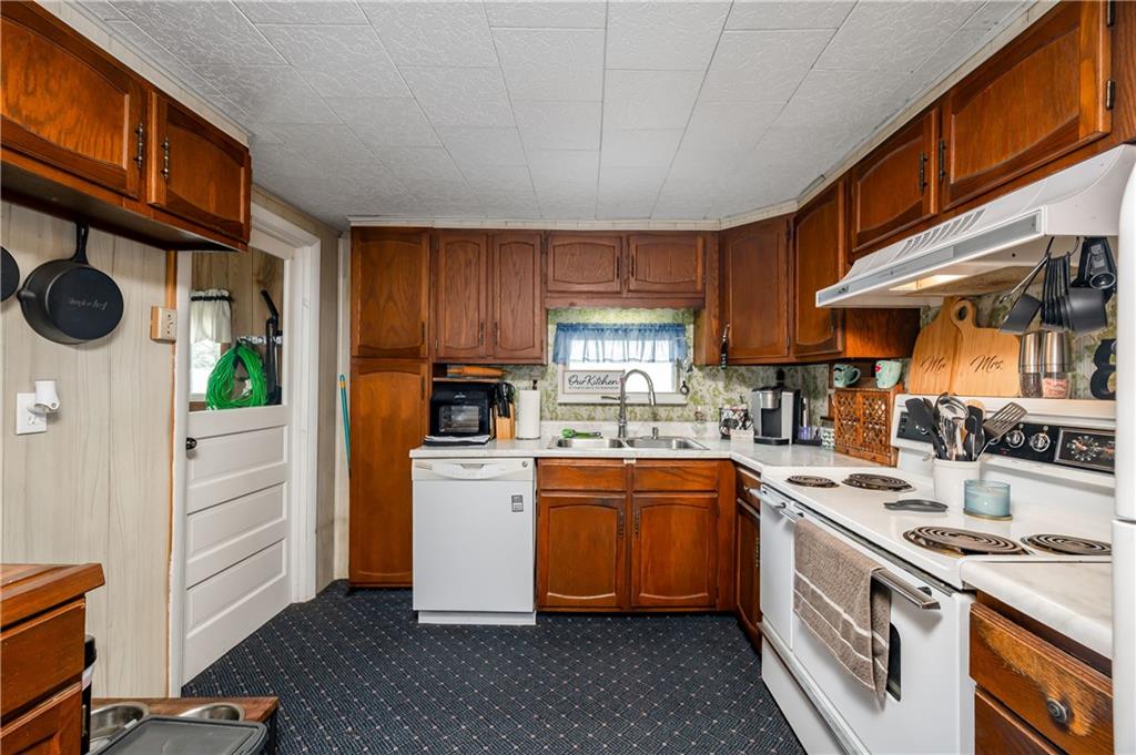 5440 Pittsburgh Road Harrisville, PA 16038 - Photo 3 of 16 a kitchen with stainless steel appliances granite countertop a stove a sink dishwasher and a refrigerator with wooden cabinets